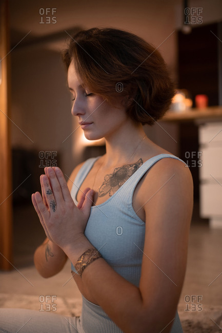 Young female meditating with clasped hands