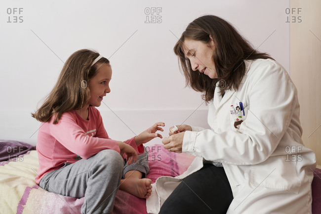 Side view of a girl looks at the doctor with a smile when she ca