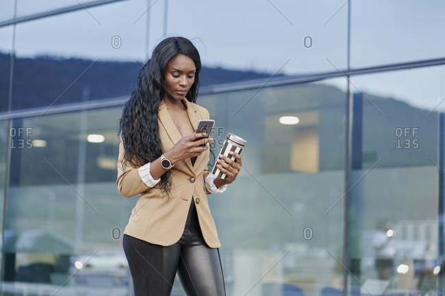 Portrait of black woman wearing a brown suit talking on the phone