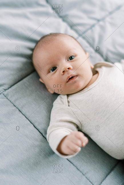 Portrait of a little newborn baby boy on a blanket on the bed