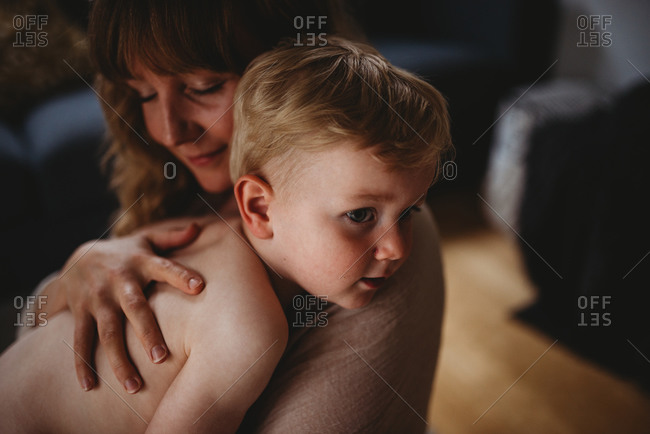 Close up of a mother closing her eyes while hugging her son at home