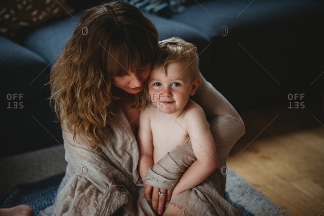 Blonde child and mom smiling sitting on the floor at home