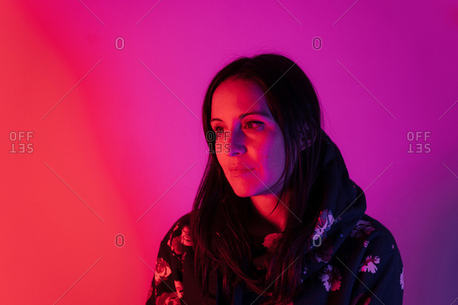 Neon light in dual tone shining on beautiful brunette woman with copy space