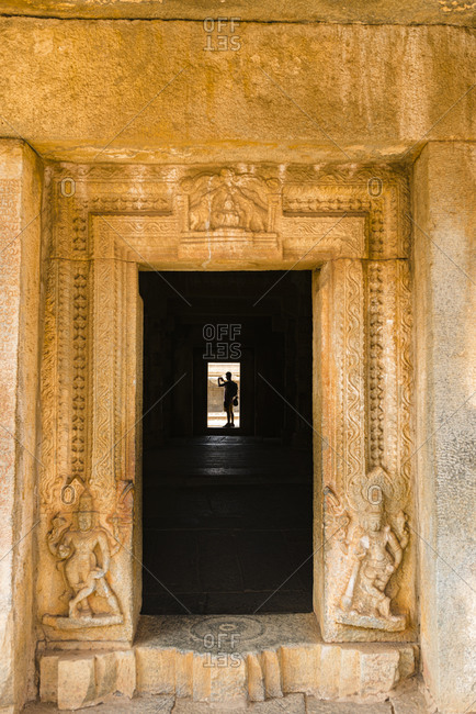 Hampi, Karnataka, India - March 27, 2019: Decorated door in the granite in Temple of Vijaya Vitthala Complex in desert valley of Hampi