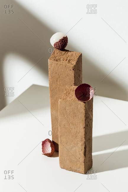 Lychee fruit on white surface with two brown blocks