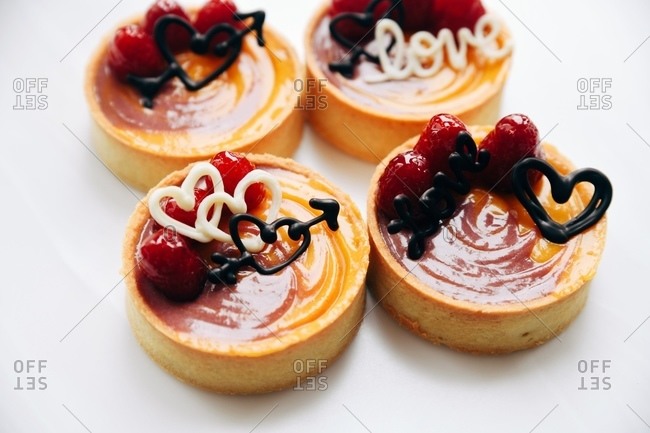 Close up of fruit tart miniature Valentine desserts on white surface