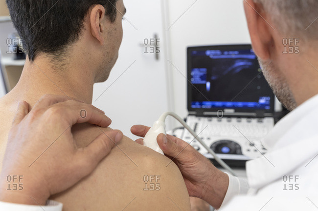A doctor performs an ultrasound on a patient's shoulder