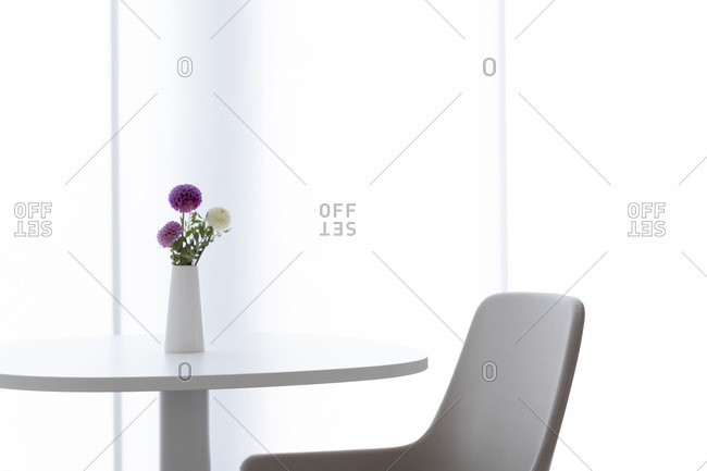 In a refined style, a table with a privatvase containing three flowers