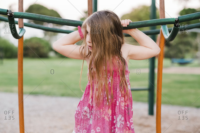 Girl holding onto equipment at the playground