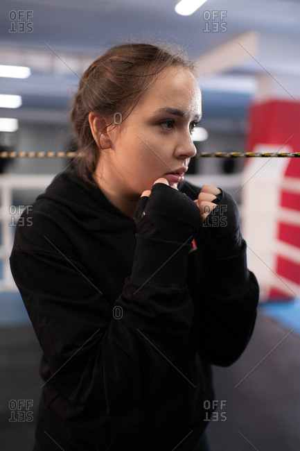 Young sportswoman practicing shadow boxing in gym