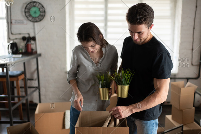 Couple examining belongings in carton box during relocation