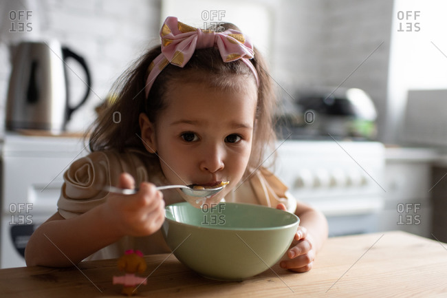 Little girl eating cereals for breakfast