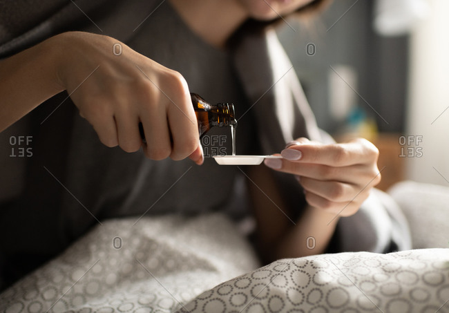 Crop female pouring syrup in spoon