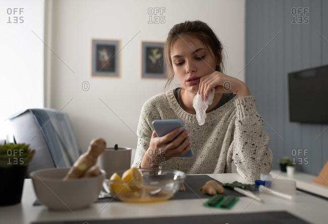 Ill woman using smartphone at home