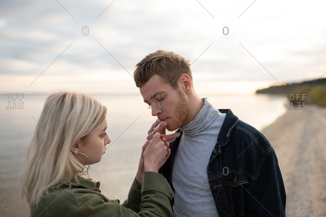 Woman lighting cigarette for boyfriend