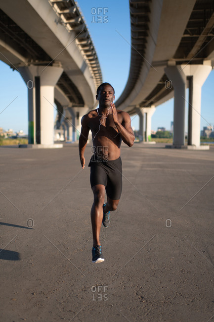 African American male running fast on track