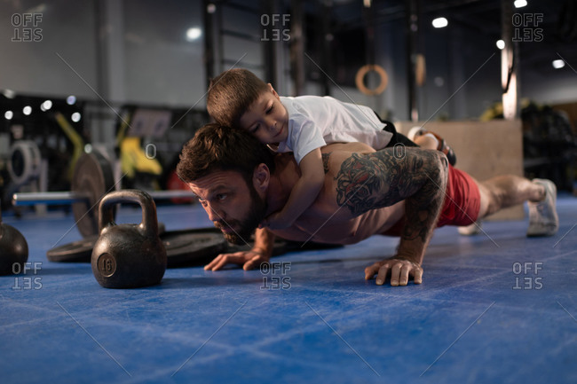 Father and son doing push ups together in gym