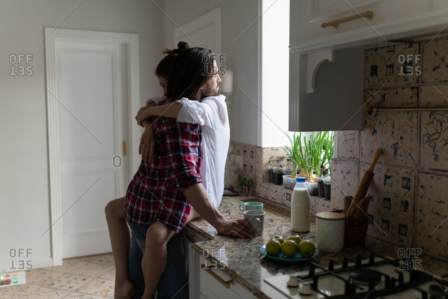 Lovely beautiful couple standing and hugging on a kitchen
