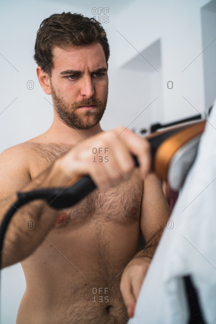 Man ironing shirt in morning