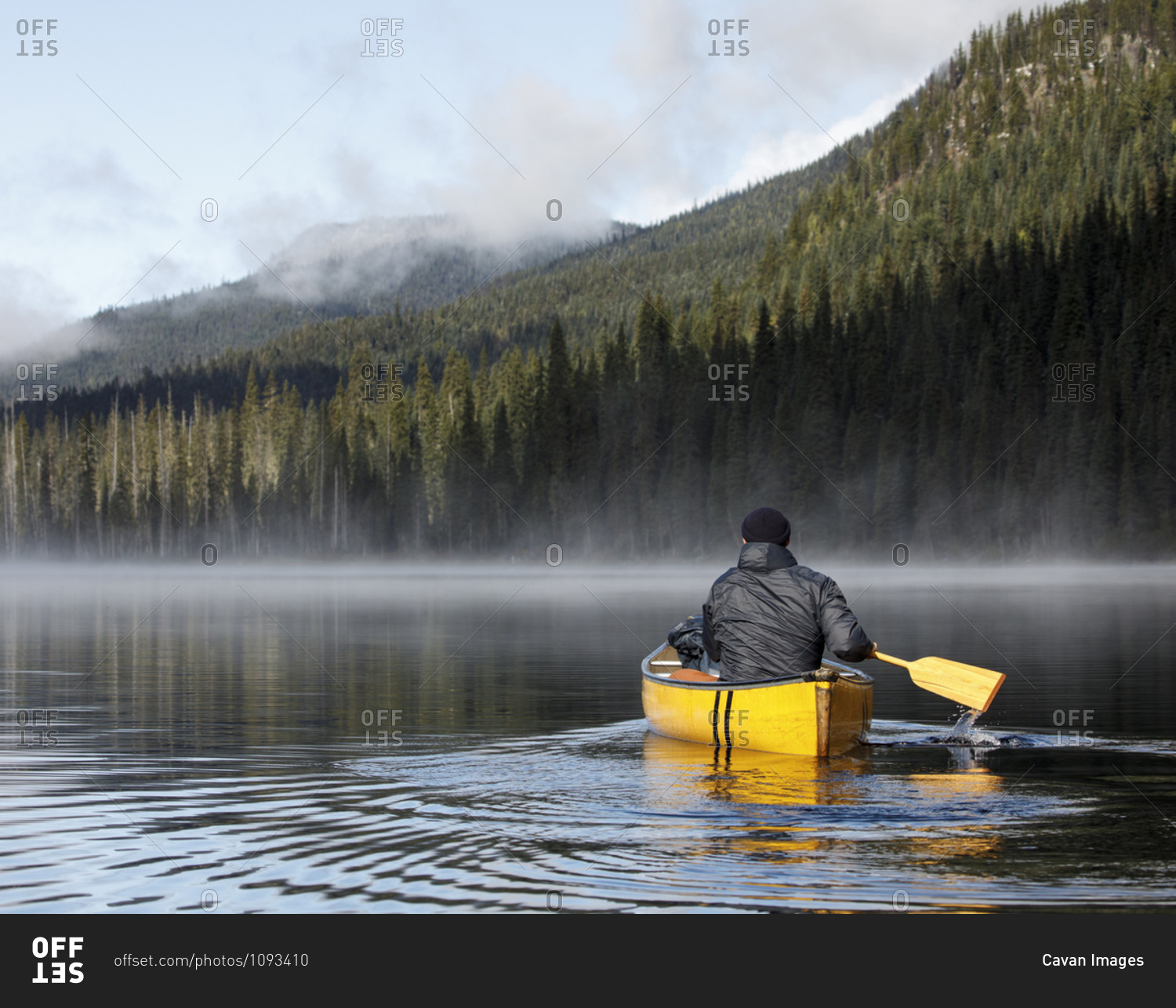 Back View Of Man Paddling Boat On Calm Misty Lake In Canada Stock Photo   Offset 1093410 