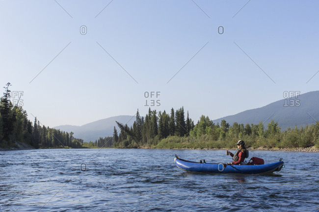 A young woman floats on a north fork of the flathead river.