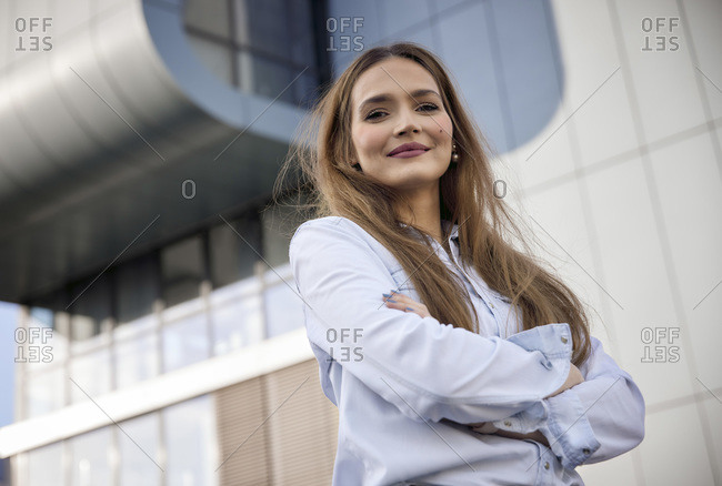 Confident businesswoman with arms crossed standing outdoors