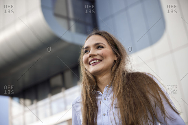 Smiling businesswoman looking away while standing outdoors