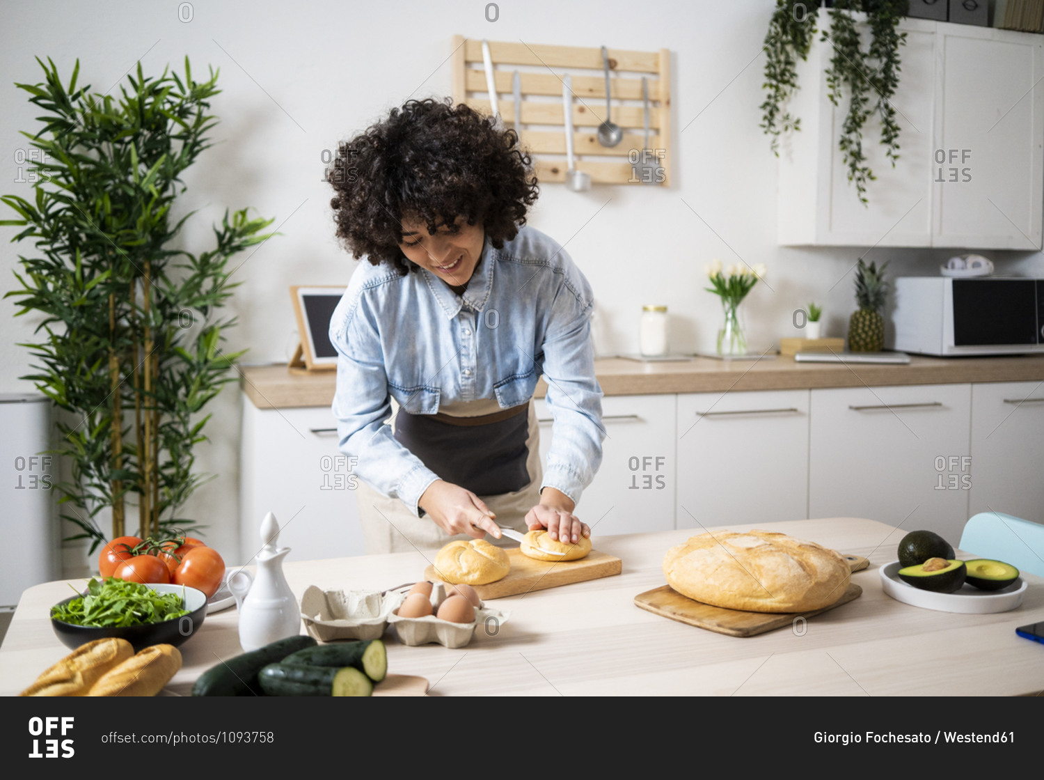 Young woman preparing vegan sandwiches in kitchen