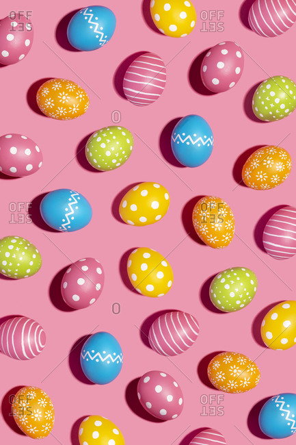 Colorful decorated Easter eggs on pink background