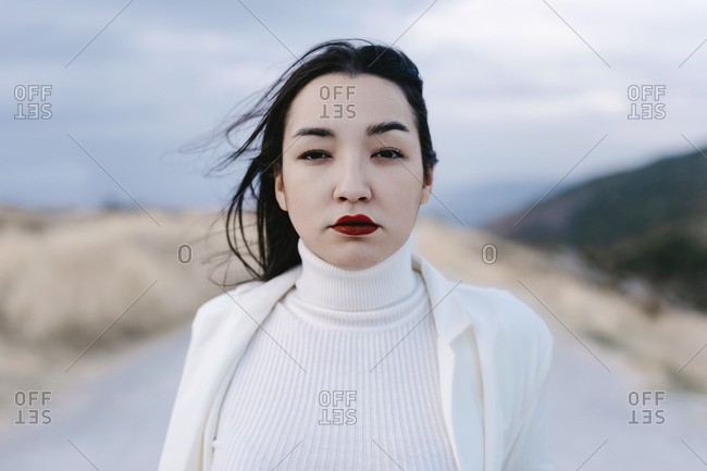 Sad woman staring while standing against sky