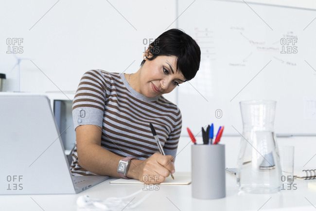 Portrait of businesswoman doing paperwork at office desk