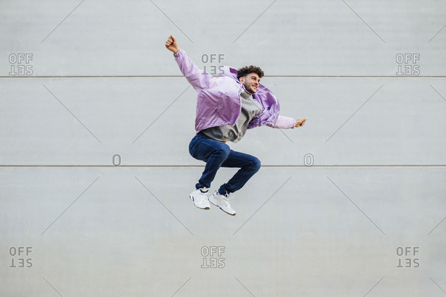 Man jumping with arms and legs out stretched stock photo - OFFSET