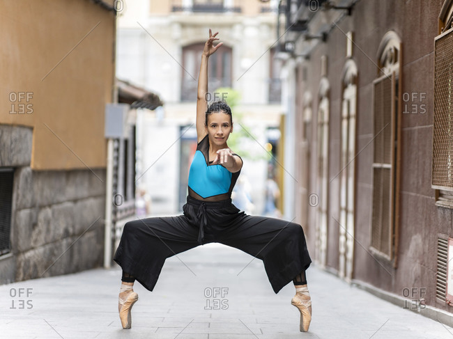 Passionate ballet dancer dancing while standing tiptoe on footpath