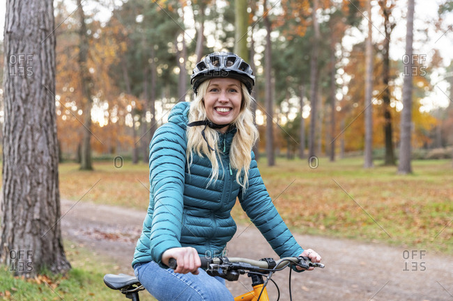Smiling woman holding bicycle while standing at Cannock Chase
