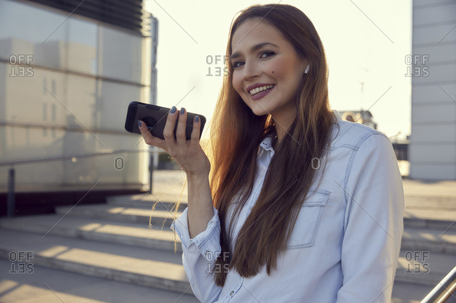 Smiling businesswoman talking on mobile phone while standing on steps