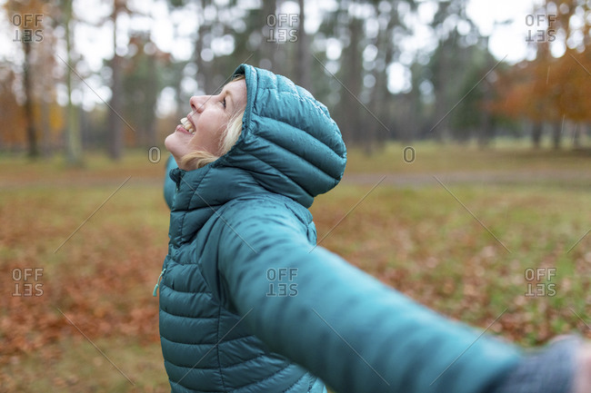 Happy woman with arms outstretched getting wet at Cannock Chase