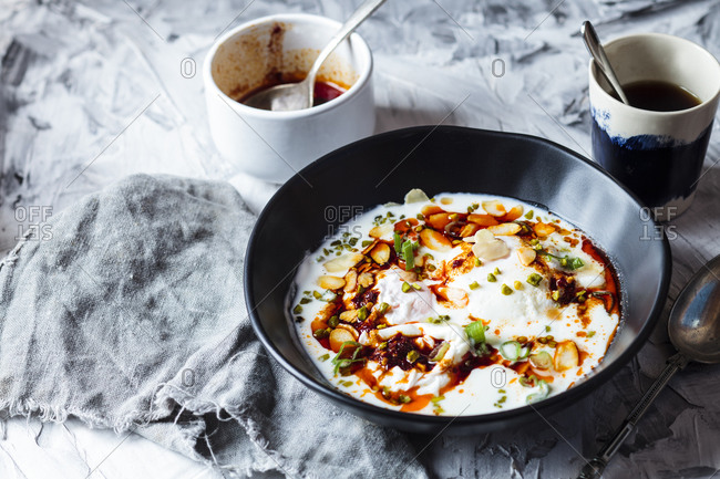 Poached eggs breakfast with yogurt and spicy paprika butter in bowl on table