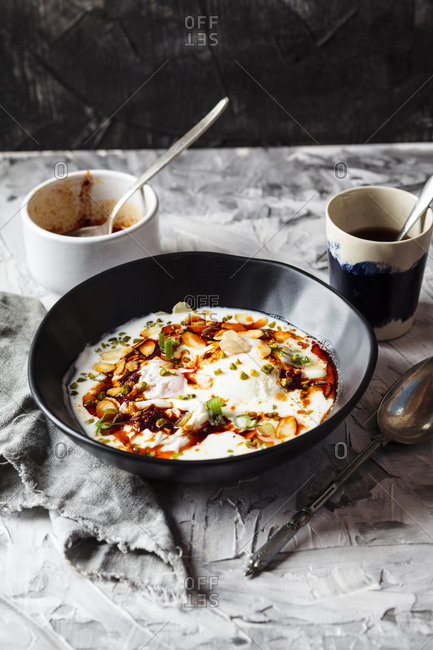 Breakfast of poached eggs with yogurt and spicy paprika butter in bowl on table
