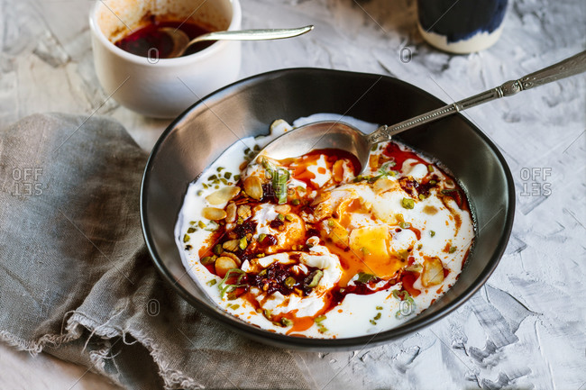 Close-up of yogurt and spicy paprika butter on poached eggs in bowl on table