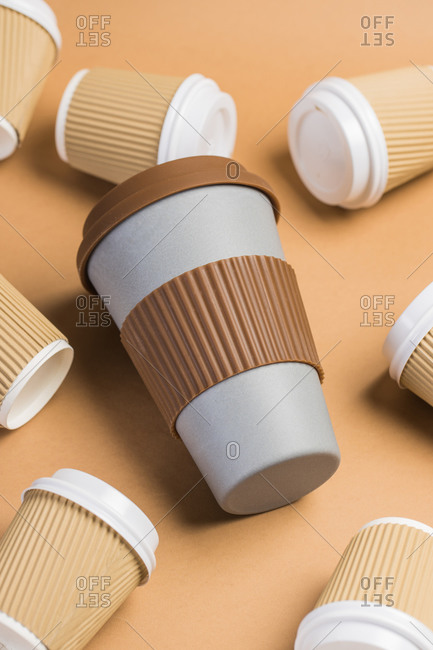 From above of various disposable cups of hot drinks placed on wooden table in cafe