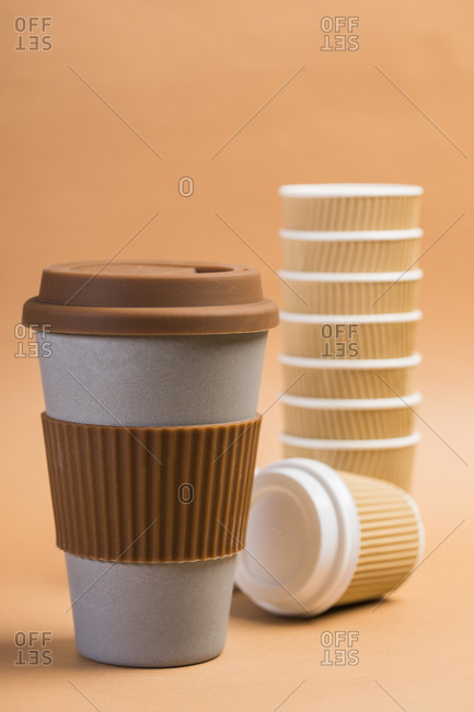 Various disposable cups of hot drinks placed on wooden table in cafe