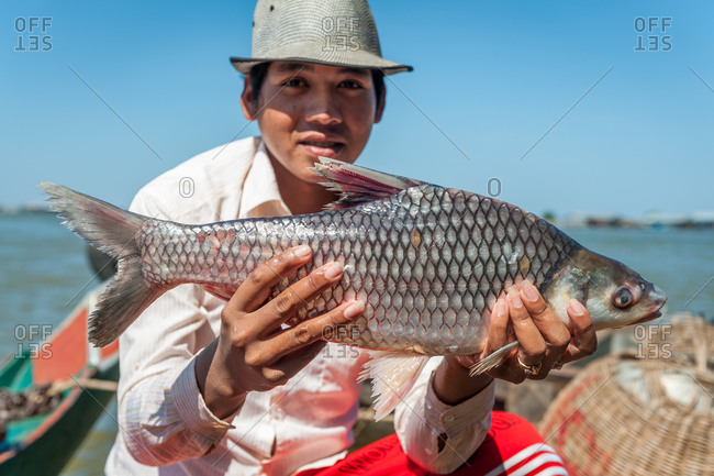 Floating Village, Kompong Chnang, Cambodia - 30 November 2009: Cambodian Fisherman Holds Up Freshly Caught Fish.