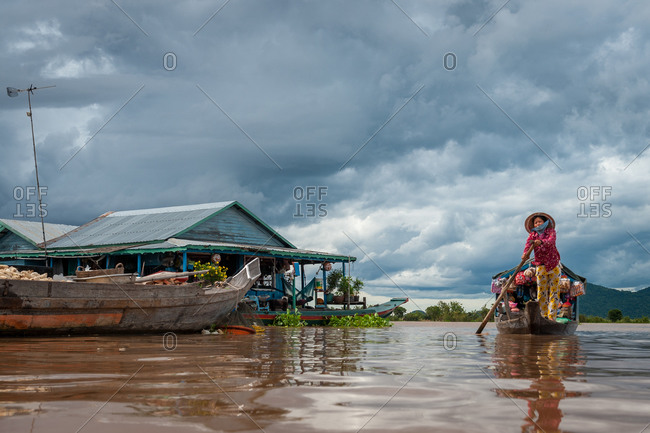 Floating Village, Kompong Chnang, Cambodia - 10 August 2011: Cambodian Lady Rows Past Houses With Floating Shop.