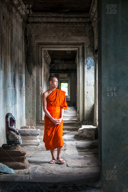 Monk In Angkor Wat, Angkor Park, Siem Reap, Cambodia - 08 October 2011: Lone Monk Walks Through Upper Gallery Of Main Temple While Looking Out Of Window.