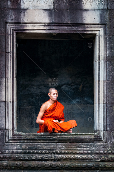 Monk In Angkor Wat, Angkor Park, Siem Reap, Cambodia - 08 October 2011: Lone Monk Meditates In Window Of Upper Gallery In Main Temple.