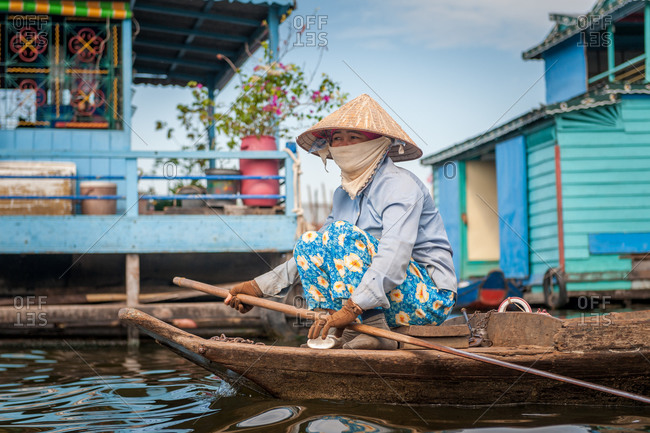 Kompong Luong Floating Village, Krakor District, Cambodia - 10 January 2012: Khmer Lady Rows Past Houses In Cambodian Floating Village.