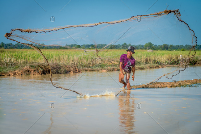 Throwing Fishing Net, Siem Reap Province, Cambodia - 23 June 2012: Cambodian Farmer Goes Fishing For Lunch.