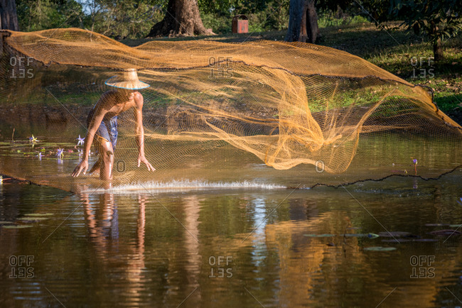 Throwing Fishing Net, Moat Of Kraven Temple, Cambodia - 11 January 2013: Young Khmer Fishes In The Moat Of An Angkorian Temple.