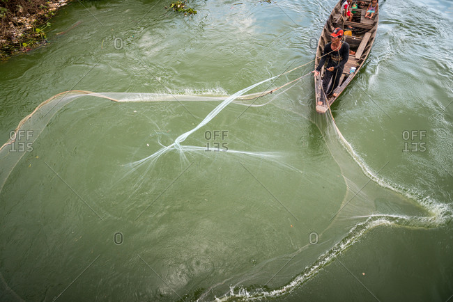 Throwing Fishing Net, Phnom Penh, Cambodia - 17 October 2013: High Angle Shot From Bridge Of Fisherman On Tributary To The Tonle Sap River Near Phnom Penh.