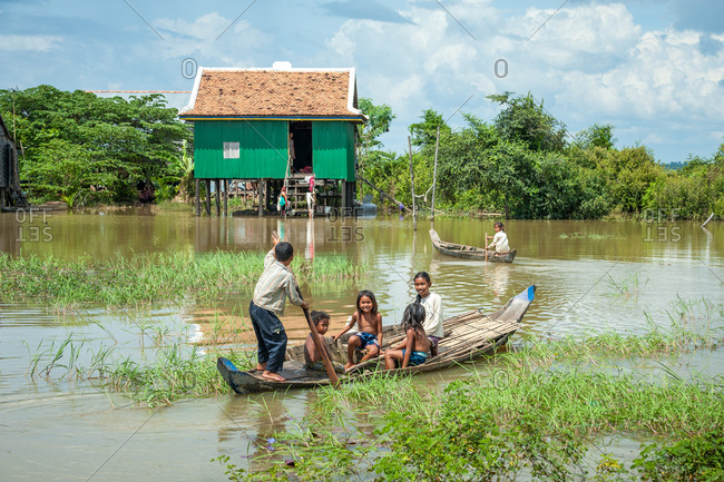 Small Wooden Boat, Kompong Thom Province, Cambodia - 17 October 2013: Small Wooden Boat Ferrying Children To Houses Isolated By Flood Waters.